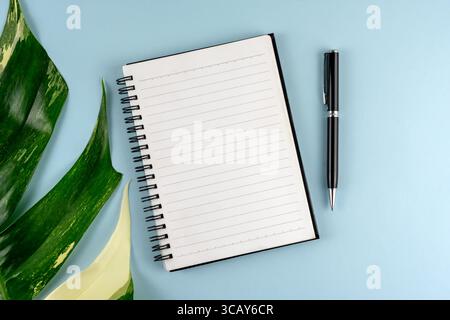 Top view of blank notepad and pen on blue background Stock Photo