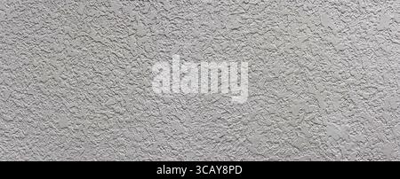 Rough textured surface of a gray concrete wall creates an intriguing pattern, ideal for backgrounds and textures Stock Photo