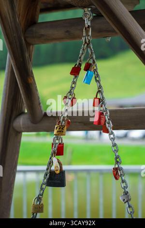 Lots of colorful padlocks hanging on a chain. Locks hung in pairs as a sign of their love. Symbol of eternal love. Stock Photo