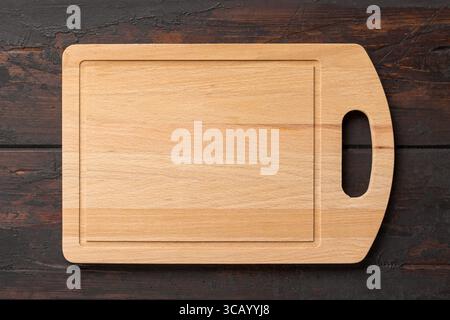 New rectangular bamboo wooden cutting board on wooden table. Top view. Mock up for food project Stock Photo