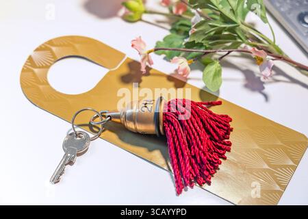 Classic vintage hotel key with red silk tassel on the table Stock Photo