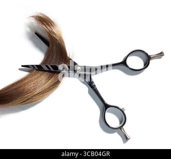 brown hair lock and scissors isolated on white background, top view Stock Photo