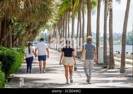 Miami Florida,Biscayne Boulevard,Maurice A. Ferre MAF Park view,baywalk couples,adult adults,man men male,woman women lady female,walking along palm t Stock Photo