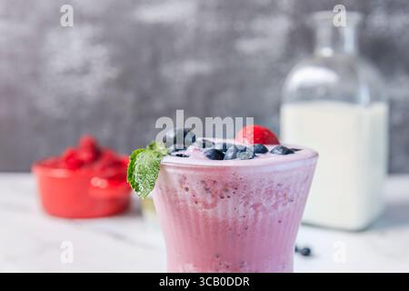 Blueberry and Raspberry Smoothie: A deep purple hue in a clear glass, with a long spoon inviting you to enjoy its silky texture Stock Photo