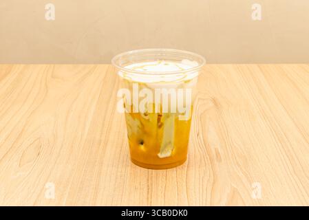 A fusion of oriental flavors: An ice chai latte with a golden foam, floating spices, and a hint of honey that melts into the crisp ice Stock Photo