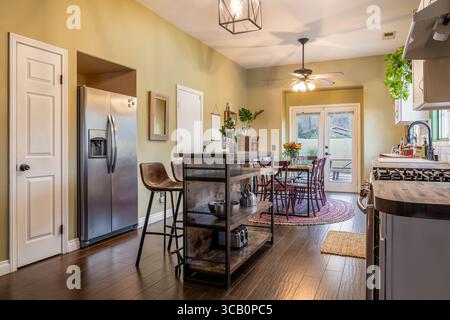 Home kitchen open floor plan with dining table, refrigerator, and cooking cart Stock Photo
