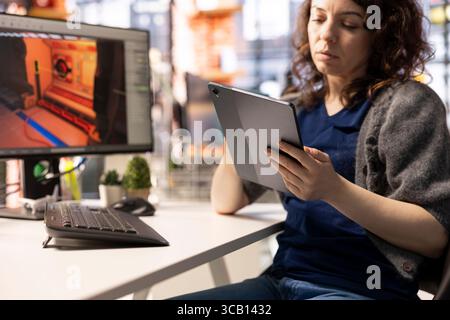 Young woman takes notes and uses AI chatbot to develop a sci fi game, working with artificial intelligence app to design a futuristic Mars station and spaceship. Virtual environments in real time. Stock Photo