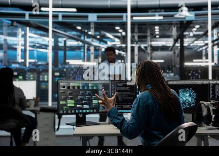 Data center admin raging, upset by errors while using AI visualization to oversee automated tasks. Mad server hub expert annoyed by glitches while modifying systems based on data analytics graphs Stock Photo