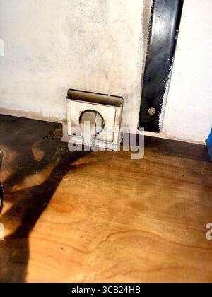 Burnt electrical socket showing signs of overheating and posing a potential fire hazard in a home. Stock Photo