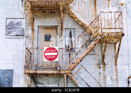 Very rusty exterior stairwell on a building with a do not enter sign Stock Photo