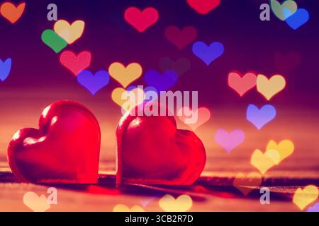 Red little decorative hearts on wooden background with hearts bokeh lights. Love or romantic Valentine day concept Stock Photo