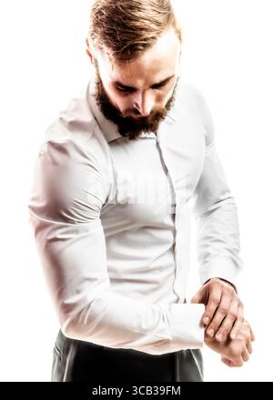A man with a beard is adjusting his cufflink. Stock Photo