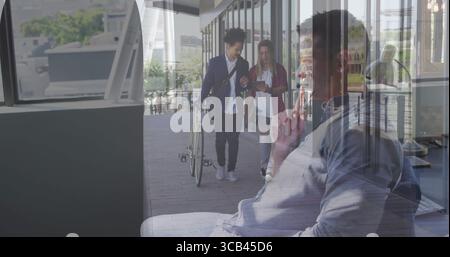 Middle-aged man wearing shirt, talking on smartphone, sitting on lounge bench in office, copy space Stock Photo