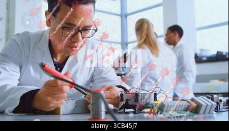 Soldering man in white coat using soldering iron on circuit board at lab bench, with microscope Stock Photo