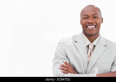 African American man crossing arms in studio wearing gray suit and striped tie, copy space Stock Photo