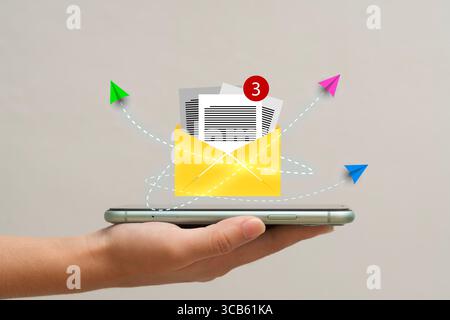 Creative email alert concept. Smartphone showing envelope with new message notification and paper planes flying. Representing mobile email, inbox, dig Stock Photo