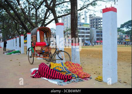 January 5, 2024: Sylhet-Bangladesh: Floating people sleep in the foggy winter  morning on the sidewalk next to the Sylhet Alia Madrasah grounds. Due to the increase in the prices of daily necessities, people are moving from poverty to more poverty, they are moving from villages to cities in search of work. The photo was taken early Friday morning. ....According to the population census in 2011 by the Bangladesh Bureau of Statistics (BBS), the Sylhet population was 479,837. The present population growth rate in Sylhet town is 2.5% per year. Considering 10% floating population comes to the city Stock Photo