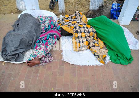 January 5, 2024: Sylhet-Bangladesh: Floating people sleep in the foggy winter  morning on the sidewalk next to the Sylhet Alia Madrasah grounds. Due to the increase in the prices of daily necessities, people are moving from poverty to more poverty, they are moving from villages to cities in search of work. The photo was taken early Friday morning. ....According to the population census in 2011 by the Bangladesh Bureau of Statistics (BBS), the Sylhet population was 479,837. The present population growth rate in Sylhet town is 2.5% per year. Considering 10% floating population comes to the city Stock Photo