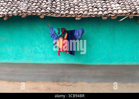 Colourful clothes drying infront of a traditional colourful house made from mud in remote part of india Stock Photo