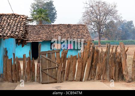 Traditional house made from mud in remote part of india, fence made from old wood, blue house Stock Photo