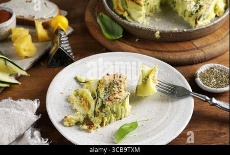 A piece of Vegetable zucchini round pie on the ceramic plate on wooden background Stock Photo