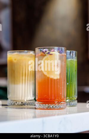 Assorted summer lemonades in glass jars with fresh fruits, ice, and colorful garnishes Stock Photo
