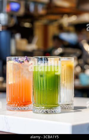 Assorted summer lemonades in glass jars with fresh fruits, ice, and colorful garnishes Stock Photo