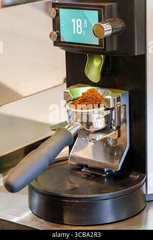 Ground coffee in portafilter ready for brewing, part of espresso preparation process in a coffee machine Stock Photo