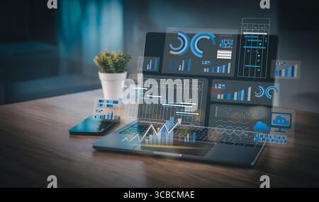 Modern business workspace showing digital analytics dashboard and project planning charts on laptop and smartphone, ideal for data-driven strategy and Stock Photo