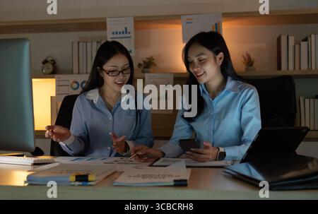 Teamwork in Action. Two women collaborating on business strategies in an office. Stock Photo