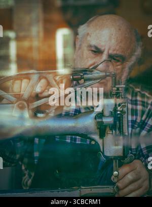 Elderly shoemaker at sewing machine in Cambridge workshop Stock Photo
