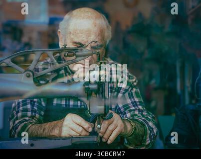 Elderly shoemaker at sewing machine in Cambridge workshop Stock Photo