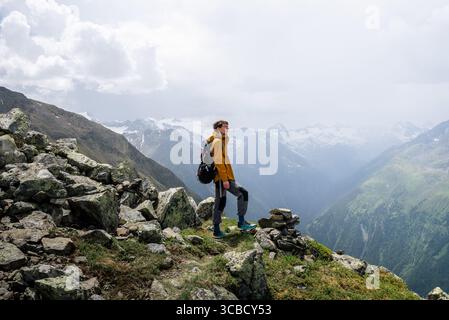 Man in yellow jacket standing on alpine summit in Austria Stock Photo
