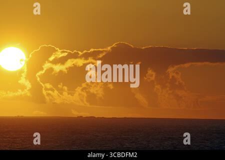 Sunset over the sea with bright sun and dramatic clouds, crossing between Orkney and Shetland Islands, Scotland, Great Britain Stock Photo