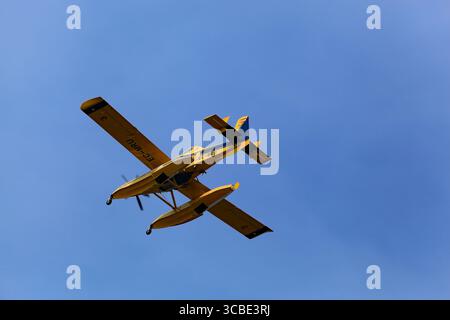 Viana do Castelo, Portugal - July 29, 2025: Yellow Air Tractor AT-802F Fire Boss EC-MRU amphibious firefighting aircraft in the air preparing to scoop Stock Photo