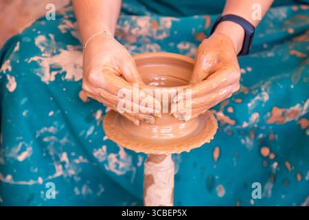Female potter making ceramic pot on the pottery wheel. Stock Photo
