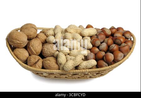 Walnuts, hazelnuts and peanuts in a wicker basket on a white background, isolated Stock Photo