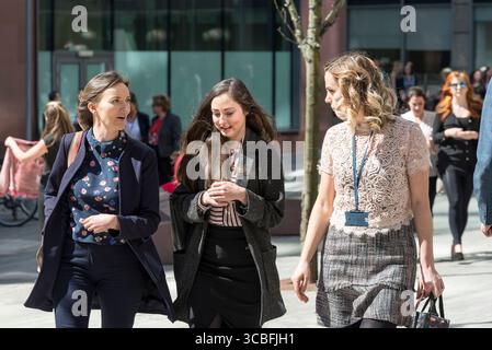 Three professional women walking and talking during lunch break in Liverpool city centre on a sunny day. Stock Photo