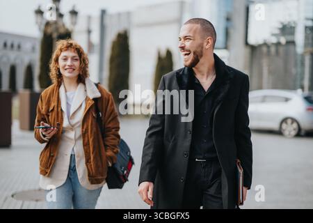 Two smiling professionals walking outdoors in urban area Stock Photo