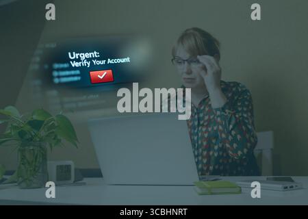 A captivating image illustrating an urgent phishing scam. Woman works on laptop and see notification that prompts the user to verify their account, a Stock Photo