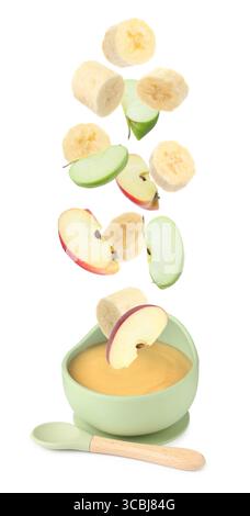 Baby food. Apple and banana slices falling into bowl of puree on white background Stock Photo