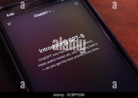 Close-up of a smartphone in dark mode displaying the GPT-5 introduction in the ChatGPT app, showcasing advanced AI features. Stock Photo