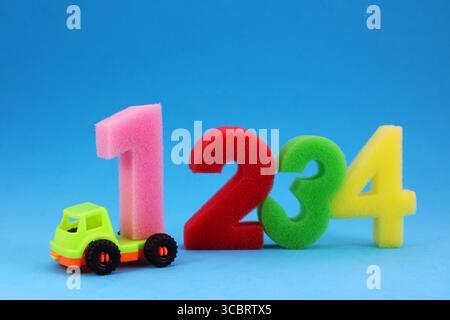 Truck delivering number one, colorful sponge numbers Stock Photo