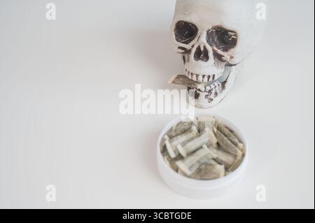 Skull Chewing Tobacco on a White Table Stock Photo