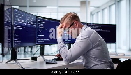 Sad Web Developer Frustrated With Coding In Office, Staring At Screen. Possible Professions: Programmer, Coder Stock Photo