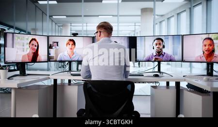 Executive Man Telecommuting From Home Office Using Multiple Monitors Stock Photo
