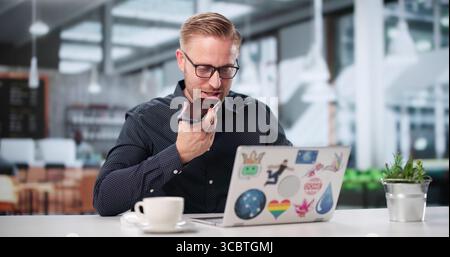 Male Graphic Designer Sends Voice Message On Phone From Coffee Shop. Stock Photo