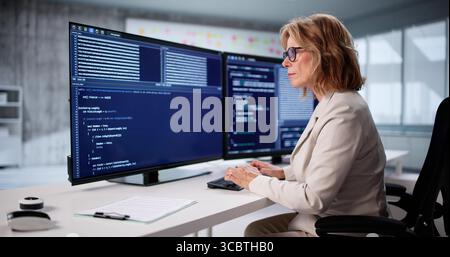 Skilled Woman Developing Cutting-Edge Software From Her Office Desktop. Stock Photo