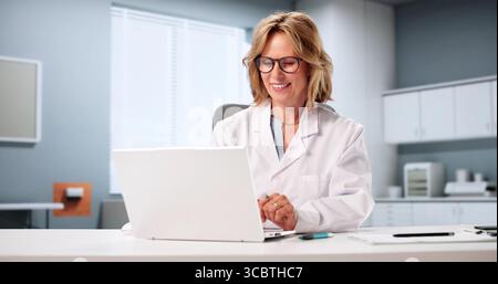 Female Doctor Smiling During Virtual Online Consultation With Elderly Patient. Stock Photo