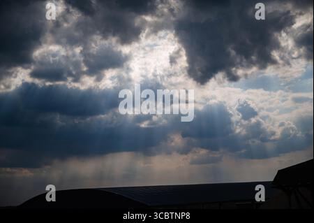 Dramatic dark clouds with penetrating rays of light. Stock Photo